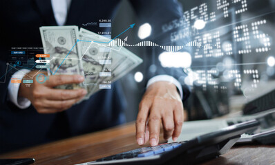 Finance accounting and banking, Businessman holding banknote in hand and using a calculator to...