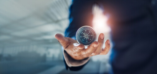 Businessman hand holding compass navigating business direction and successful strategic solution.Reflect accomplishment in terms of research and development growth market and financial profitability.