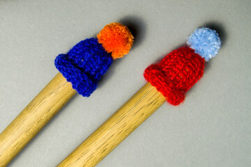 little knitted hats sit on drum sticks