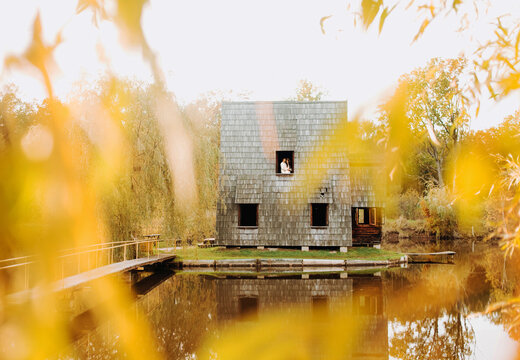 Wooden Whimsical Cozy House In The Autumn Park Near The Lake And A Couple In Love