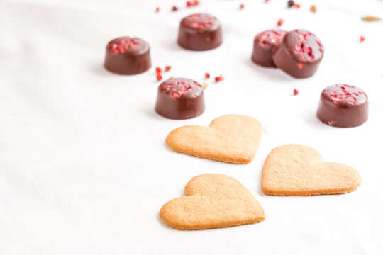 Valentine's Day background. Valentine's Day heart shape cookies with chocolates on the background. Selective focus