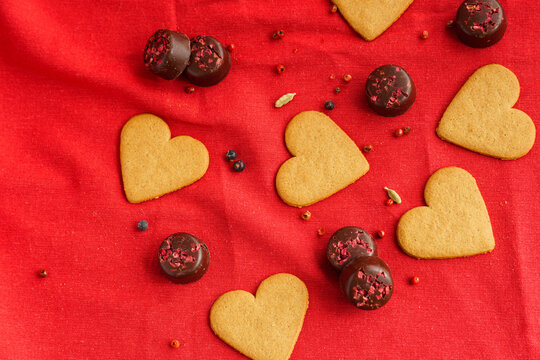 Valentine's day cookies with heart shape isolated on red with some chocolates on the background. Valentine's day concept. Selective focus. Top viewJPG