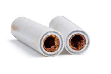 Old broken sludge plumbing polypropylene pipes with red rust and limescale. Corrosion, sludge and hard water concept. Obsolete pipes isolated on white background