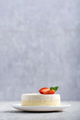 Classic cheesecake with fresh strawberries on gray background. New York dessert. Vertical frame