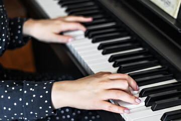 Obraz premium Hands of a young girl pianist on the keys of a synthesizer