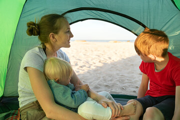 Fototapeta na wymiar Happy family holidays in tent with child in nature. Concept of traveling, hiking, camping