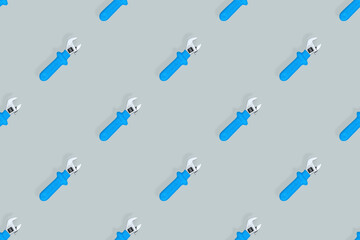 Adjustable metal wrench seamless pattern. Adjustable metal wrench on a gray background.