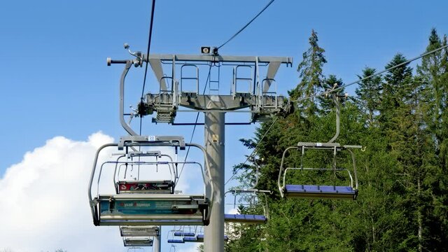 Ski lift and cable cars working on mountain ski resort at sunny summer day. Concept of travel and tourism in mountain at summer