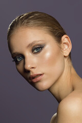  A young girl with dark evening makeup and blue eyes. Beautiful studio beauty photo. Girl with bare shoulders