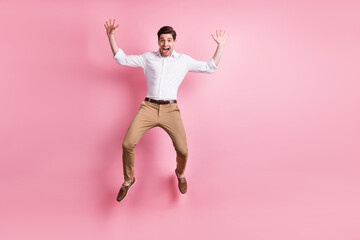 Full size photo of optimistic guy jump wear white shirt trousers sneakers isolated on pink color background