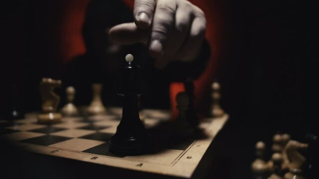 Close up of Unrecognizable Man in Hoodie Moving White Queen Defeating White King of Opponent During Chess Game. Competition Leadership and Checkmate Concept