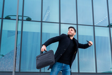 Young businessman wants to throw his cell phone in a fit of rage caused by the loss of his...