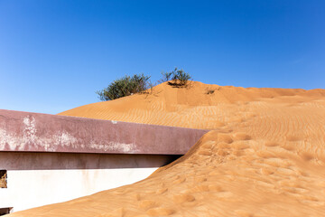 Old residential building buried in sand dune on a desert in Al Madam ghost village in Sharjah,...