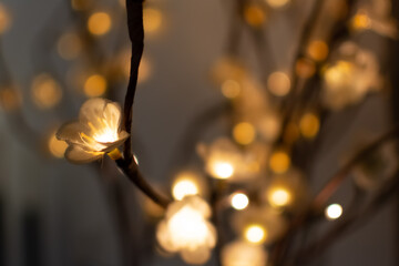 Focus on a electrical flower shaped light garland on a brown background