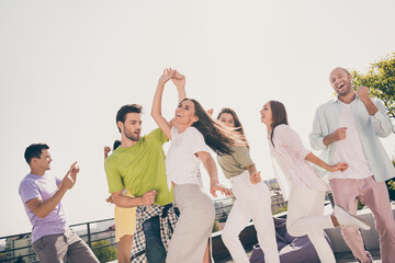 Low angle view photo of young friends excited happy smile carefree have fun enjoy music dance rest...