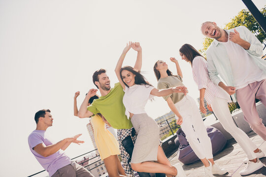 Low angle view photo of young guys excited crazy carefree have fun enjoy music dance rest rooftop party