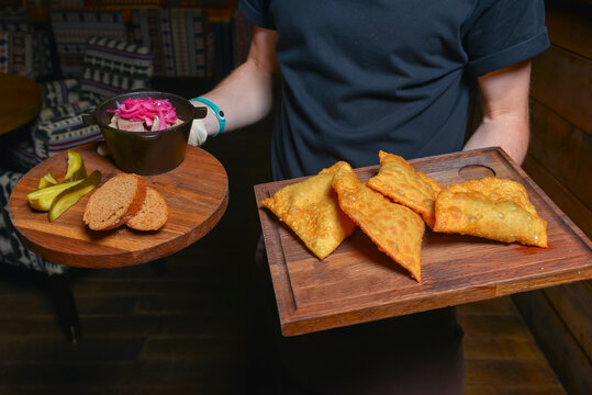 Waiter service, eating out concept. Idea for delicious meal for dinner. Cheburek with meat.