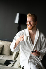 Male in bathrobe relaxing while drinking tea