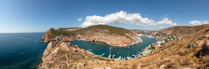 Fototapeta na wymiar panorama of a curved bay with boats and buildings in the mountains
