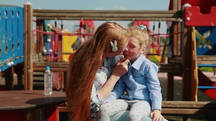 Mom and daughter talk to each other in the park.