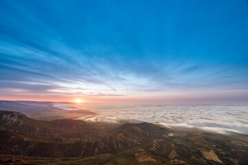 sunrise on the coast in clouds and mountains