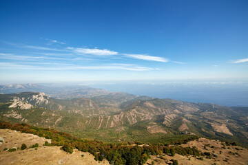 view of the coast with the sea and mountains against the blue sky from a bird's eye view