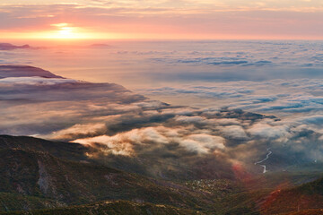 Fototapeta na wymiar sunrise on the coast in clouds and mountains