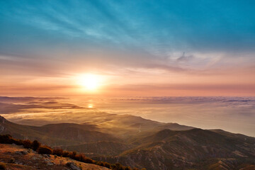 Obraz na płótnie Canvas sunrise on the coast in clouds and mountains