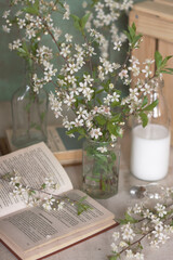 spring composition of milk bottles flowers and books on the background of vintage walls