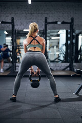 Person picking a kettlebell up during a squat