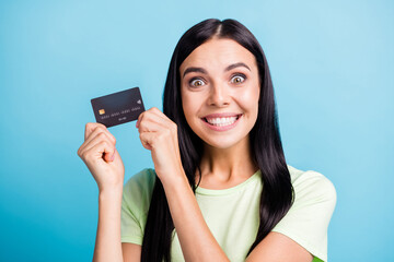 Photo portrait of excited crazy woman holding card in two hands near face isolated on pastel blue colored background