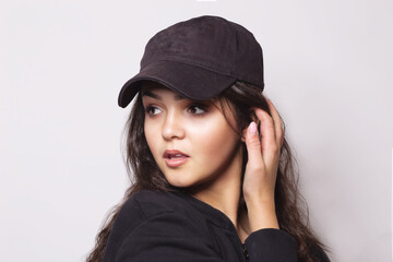 Very attractive young woman in a cap posing in studio