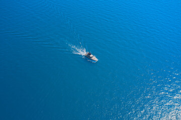 Aerial view of a white yacht on blue water. Top view of a white boat sailing in the blue sea. Drone view of a boat. luxury motor boat.