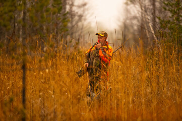 Hunter and his elkhound outdoor in the wilderness