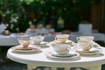 Tee und Kaffee Service auf einem Tisch im Garten mit Sonnenschein