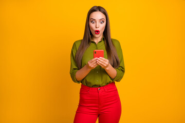 Portrait of attractive amazed straight-haired girl using device 5g browsing web reading post isolated over bright yellow color background