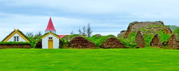 Obraz na płótnie Canvas Historical Icelandic Turf House Glaumbær in North-Iceland Skagafjodur Small Lutheran church in scenic village, green grass field in Iceland, summer season, idyllic rural landscape.