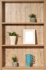 wooden shelf with succulent flowers, cups and empty picture frame. Copy space. High quality photo
