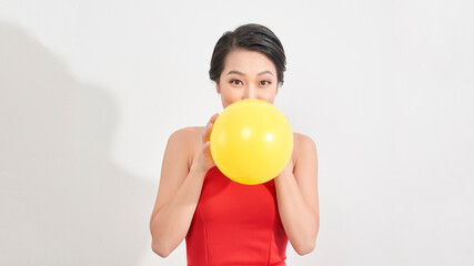 Fashion Beauty Girl blowing a yellow balloon. Gorgeous Woman Portrait. Stylish Haircut and Makeup