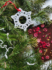 beautiful chocolate bar decorated with pumpkin seeds and berries against the background of fir branches and decorations