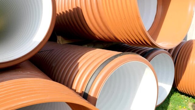 Closeup dolly shot of new plastic pipes and tubes stacked on the building site. COncept of building the infrastructure and industrial background or backdrop