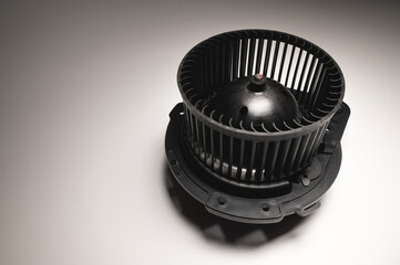 Heater motor. A spare part for an automobile heating system on a black-gray gradient background. Low key high contrast