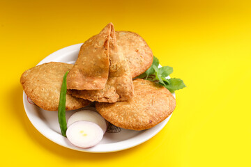 Kachori and potato samosa with green chilly in plate. famous spicy snack in india