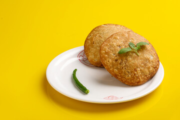 Kachori, green chilly and onion slice in plate. kachori is a spicy snack from India also spelled as kachauri and kachodi.