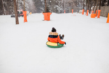 Tubing downhill - winter fun for all ages - snow trail - motion action blur