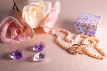 Wedding preparations. Two wedding rings, pearl beads, flowers and hearts. The photo