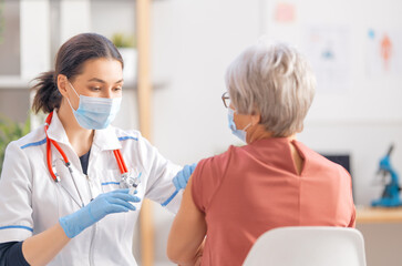 Fototapeta na wymiar Doctor giving a senior woman a vaccination