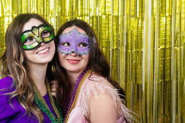 Mardi gras party. Women with a carnival mask and beads on the golden festive background