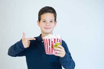 Smiling boy eating pop corn over white background.
