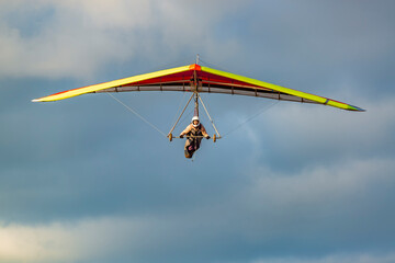 Fototapeta na wymiar Beginner girl pilot with colorful hang glider wing.